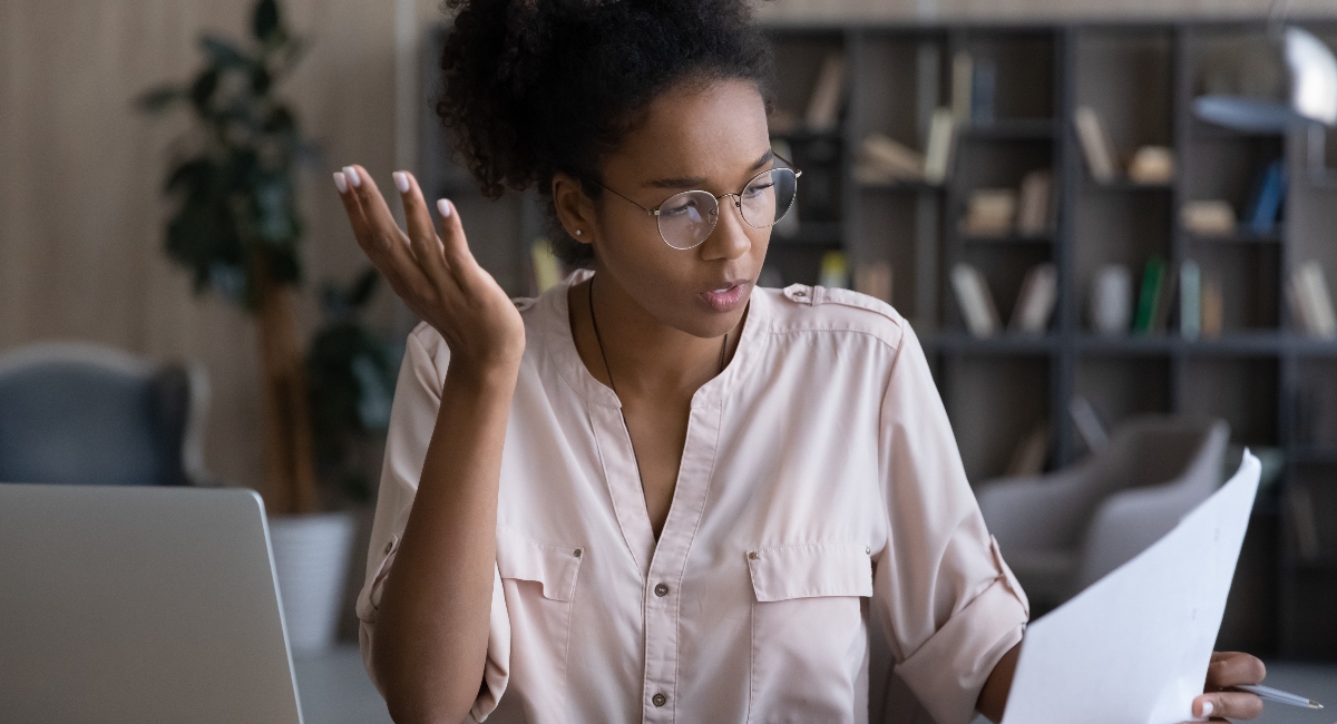 Woman reading financial papers looking confused